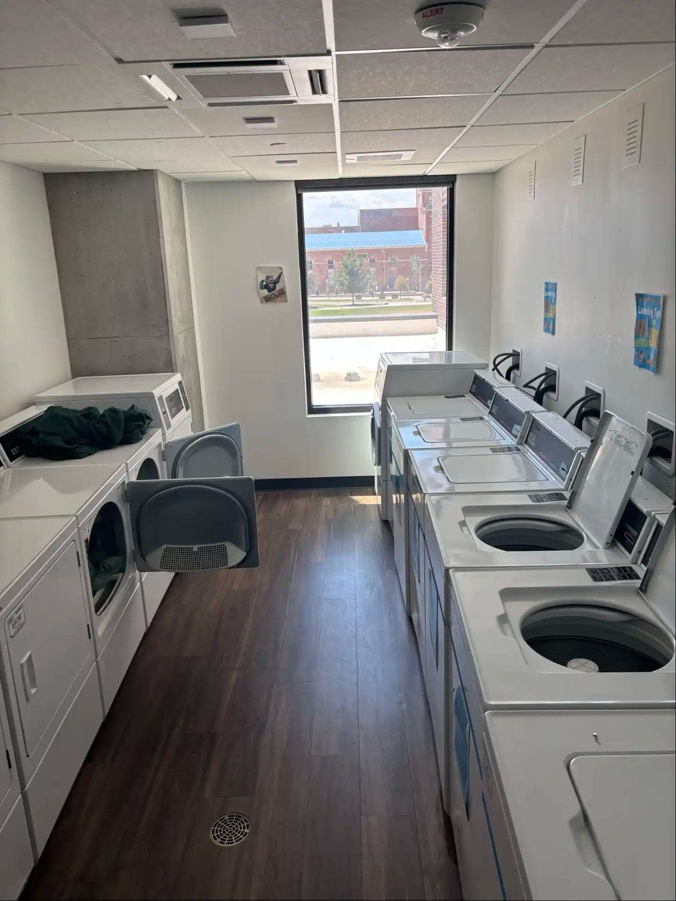 Apartment laundry room with a row of washers and dryers