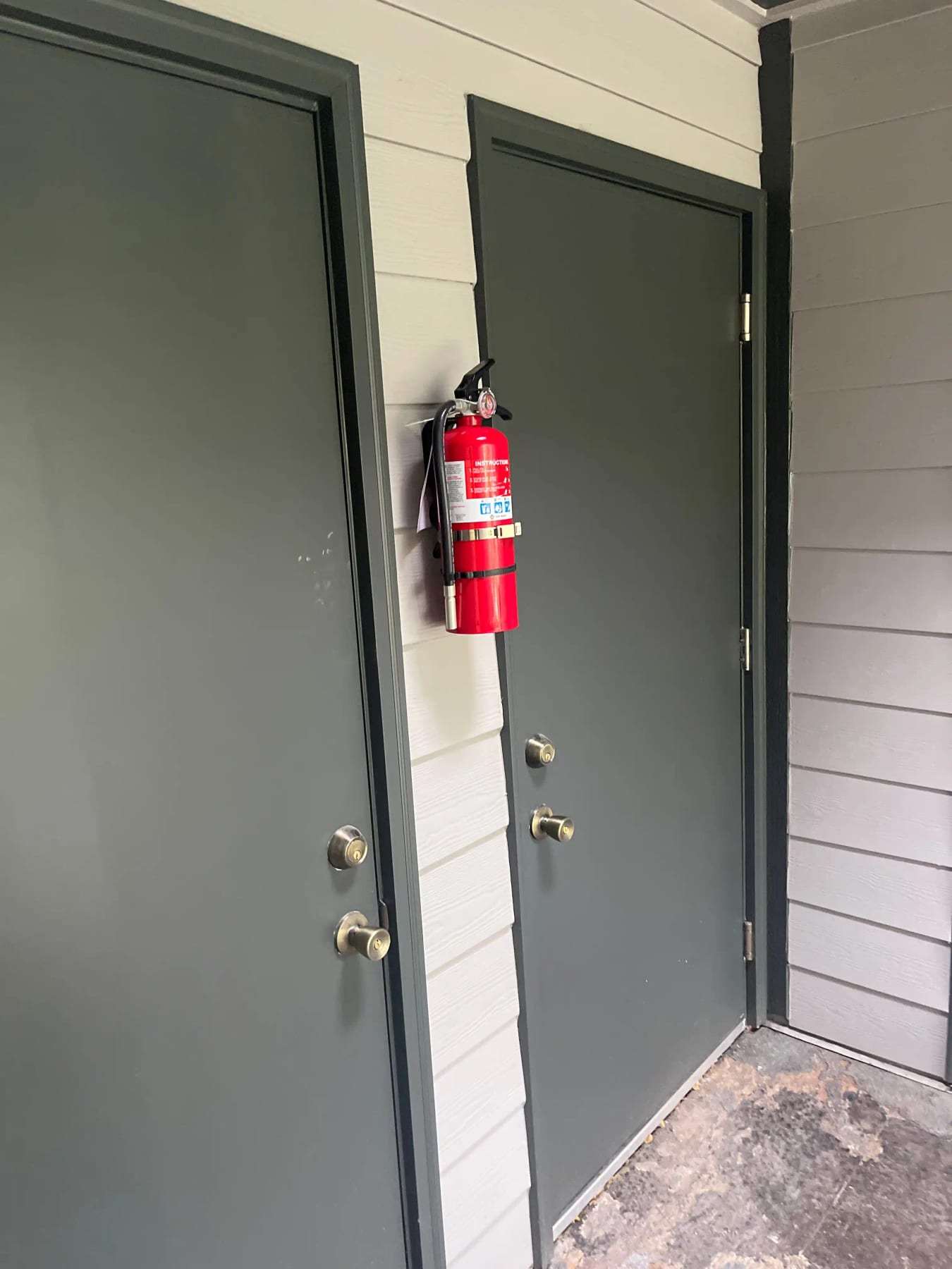 Pair of gray exterior doors with a fire extinguisher mounted beside them