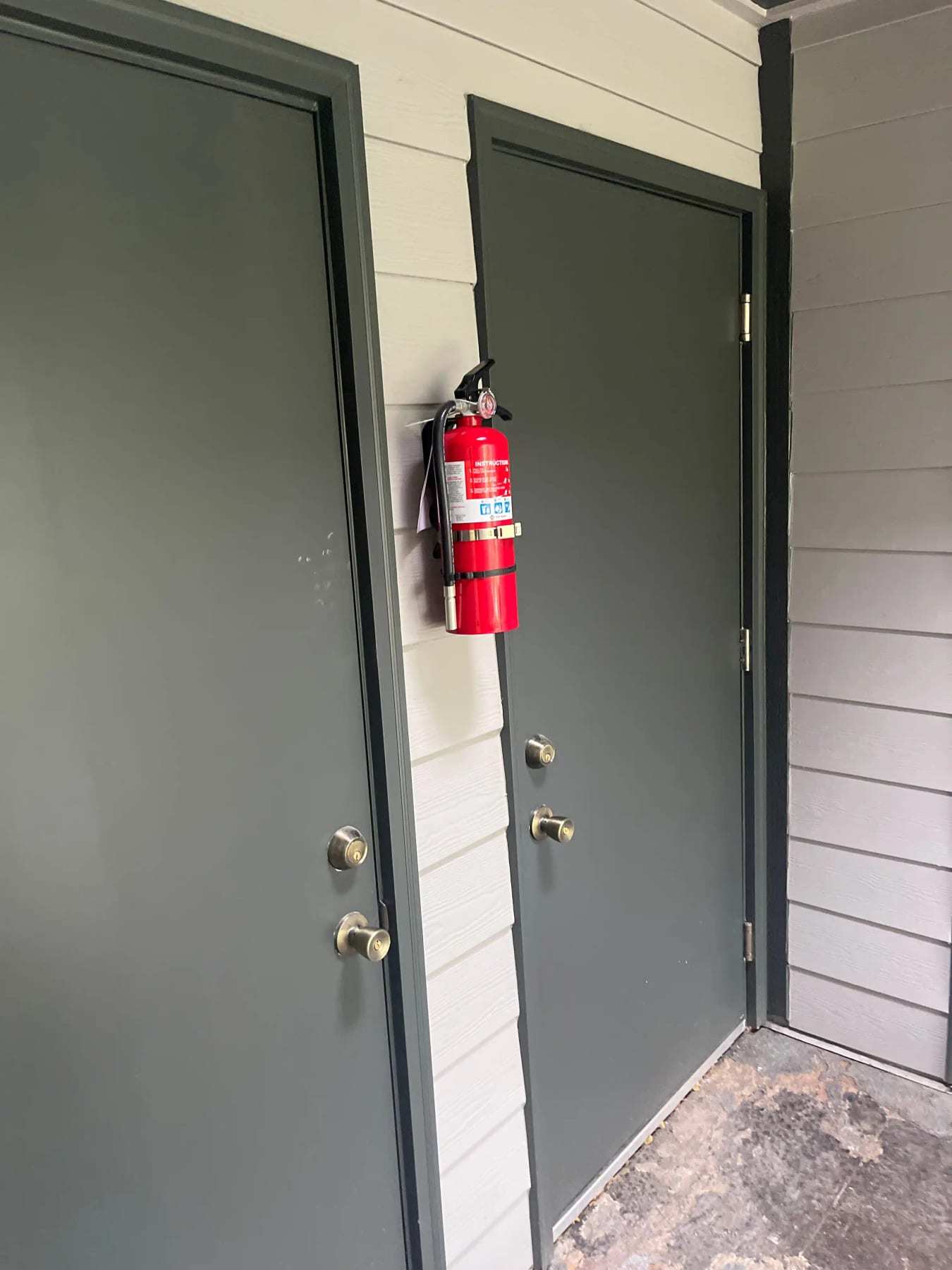 Pair of gray exterior doors with a fire extinguisher mounted beside them