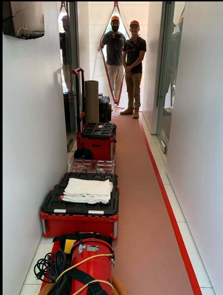 Narrow hallway with plastic containment and equipment cases